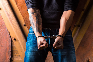 Tattooed hands of a criminal handcuffed