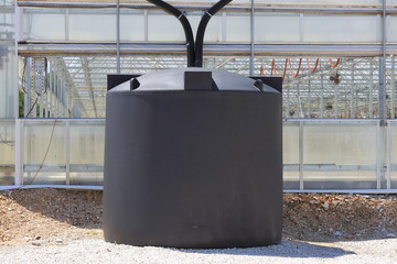 A couple of rain water collection tanks used to catch rain water off of a greenhouse. 