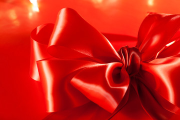 Red Silk Bow with Christmas lights in the background. 