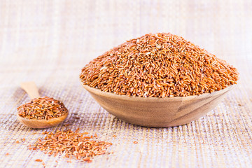Sangyod brown GI rice in a wooden bowl.