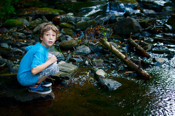young boy playing in a stream
