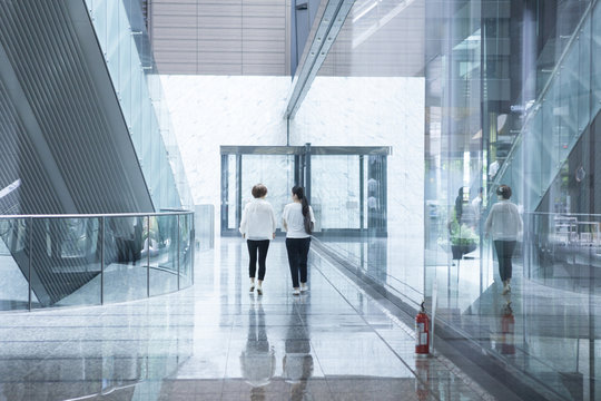 Women walking in the glass-walled building