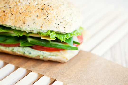 Vegetable Sandwich with sliced cucumber, tomato, lettuce and cheese on Focaccia bread with pesto. 