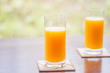 Two glasses of orange juice inyhe morning garden
