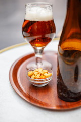 Glass with beer and nuts on the table.