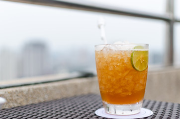 a glass of cocktail on the rooftop of building