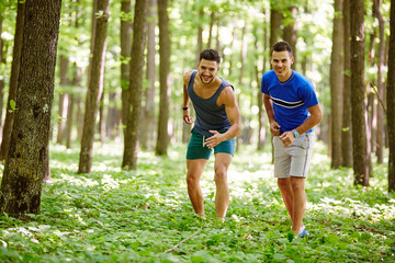 Naklejka premium Friends running through forest