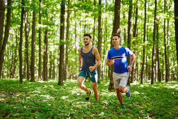 Friends running through forest