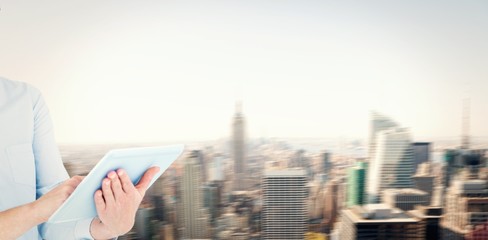 Composite image of businesswoman using tablet pc 