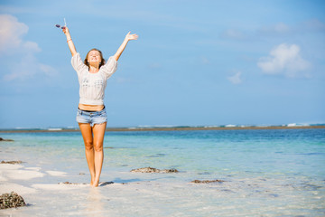 Young skinny caucasian girl at the beach waving over blue sky