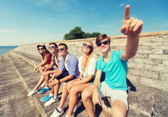 group of smiling friends sitting on city street