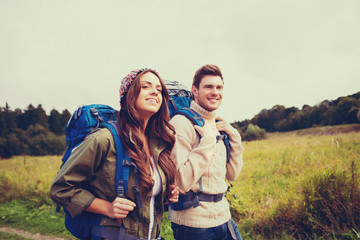 smiling couple with backpacks hiking