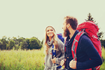 smiling couple with backpacks hiking