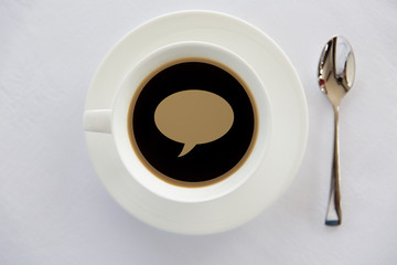 cup of black coffee with text bubble and spoon