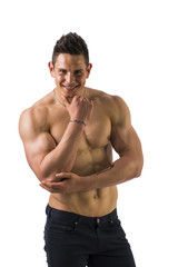 Muscular young bodybuilder in relaxed pose, smiling