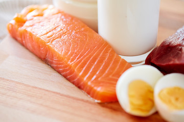 close up of salmon fillets, eggs and milk on table