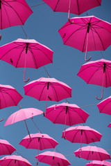 Fototapeta na wymiar Pink parasols in the air