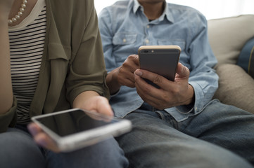 The couple are looking at a smartphone each