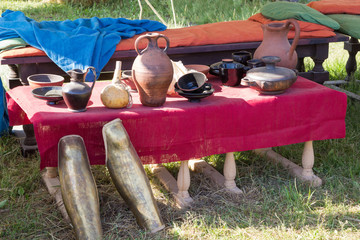 clay utensils on table with a red cloth coverings