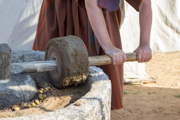 man works at ancient Roman press for olive oil