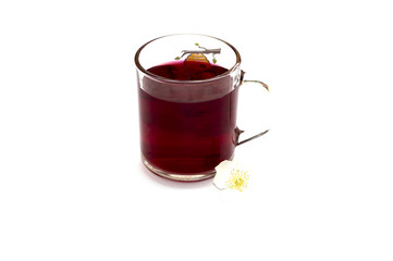 the glass of bright red tea decorated with a small flower