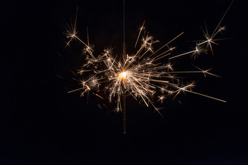 hand holding a sparkler fire on black background