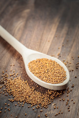 Mustard seeds on wooden spoon