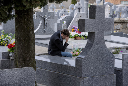 Man crying in the the tomb of a cemetery