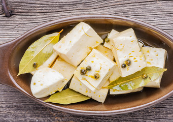 Goat feta cheese with oil in bowl