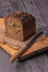 Homemade wholemeal bread on wooden table with knife
