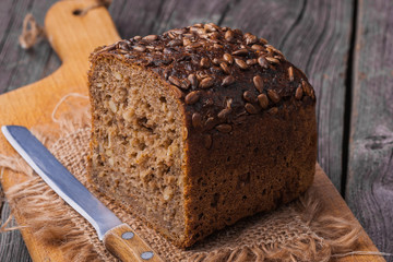 Homemade wholemeal bread on wooden table with knife