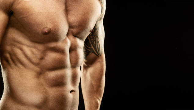Men's muscular abdomen - close-up - on black background