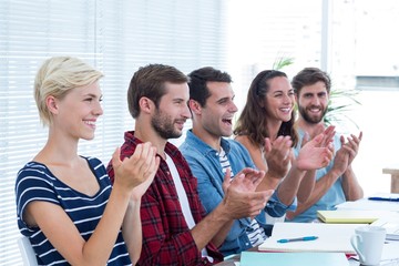 Colleagues clapping hands in meeting