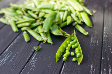 Fresh green peas scattered on the beautiful old wooden background