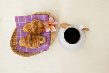 Croissant serve in basket with black coffee 