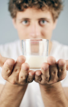 young Man presenting a glas of Milk