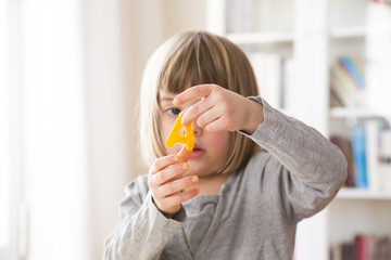 Little girl with letter A cutting out of yellow modeling clay
