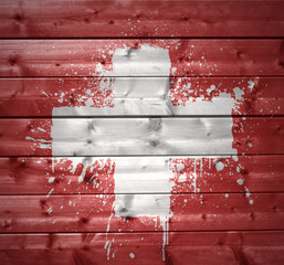 painted swiss flag on a wooden texture
