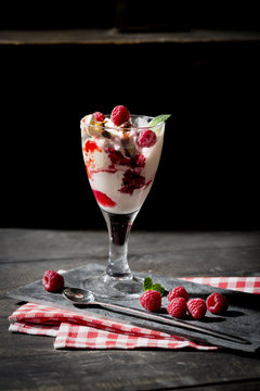 Glass of Bourbon vanilla ice with hot raspberries and chocolate sauce