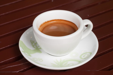 A cup of coffee in a white cup on wooden background