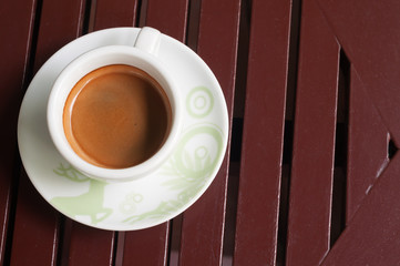 A cup of coffee in a white cup on wooden background