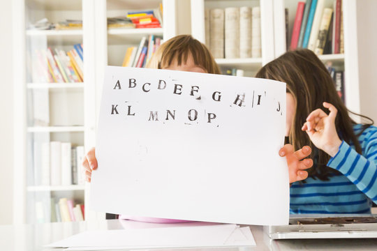 Two girls showing sheet of paper with stamping