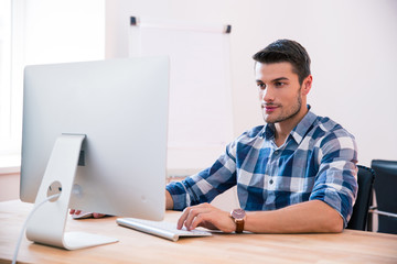Handsome businessman using PC at the table