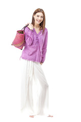 Smiling woman wearing hippie clothes holding bag.