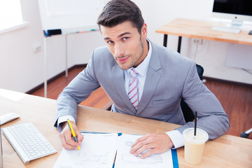 Handsome businessman signing document