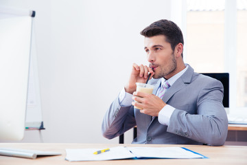 Businessman in suit drinking iced coffee with straw