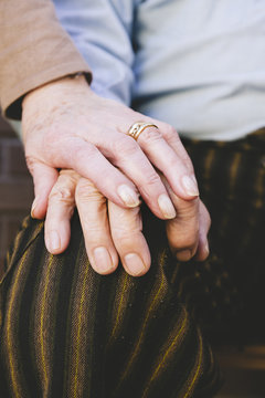 Hand of old woman on husband's hand