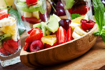 Dietary mixed fruit salad with fruit and berries in a wooden bow