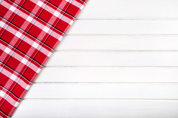 Top view of checkered kitchen towels on wooden table. 