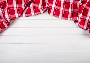 Top view of checkered kitchen towels on wooden table. 
